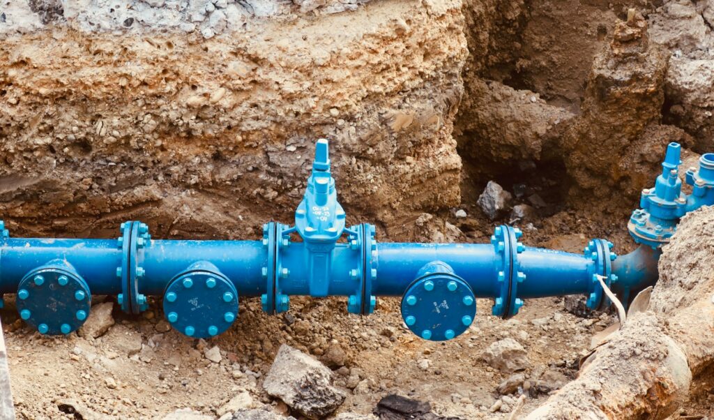 a blue pipe laying on top of a pile of dirt