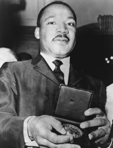 Dr. Martin Luther King showing his medallion received from Mayor Wagner.