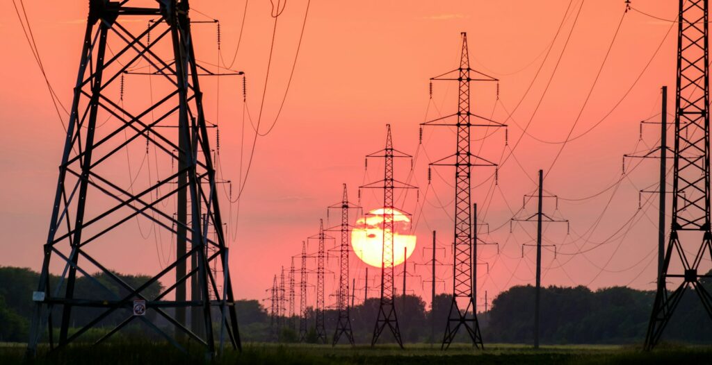 silhouette of electric post during sunset